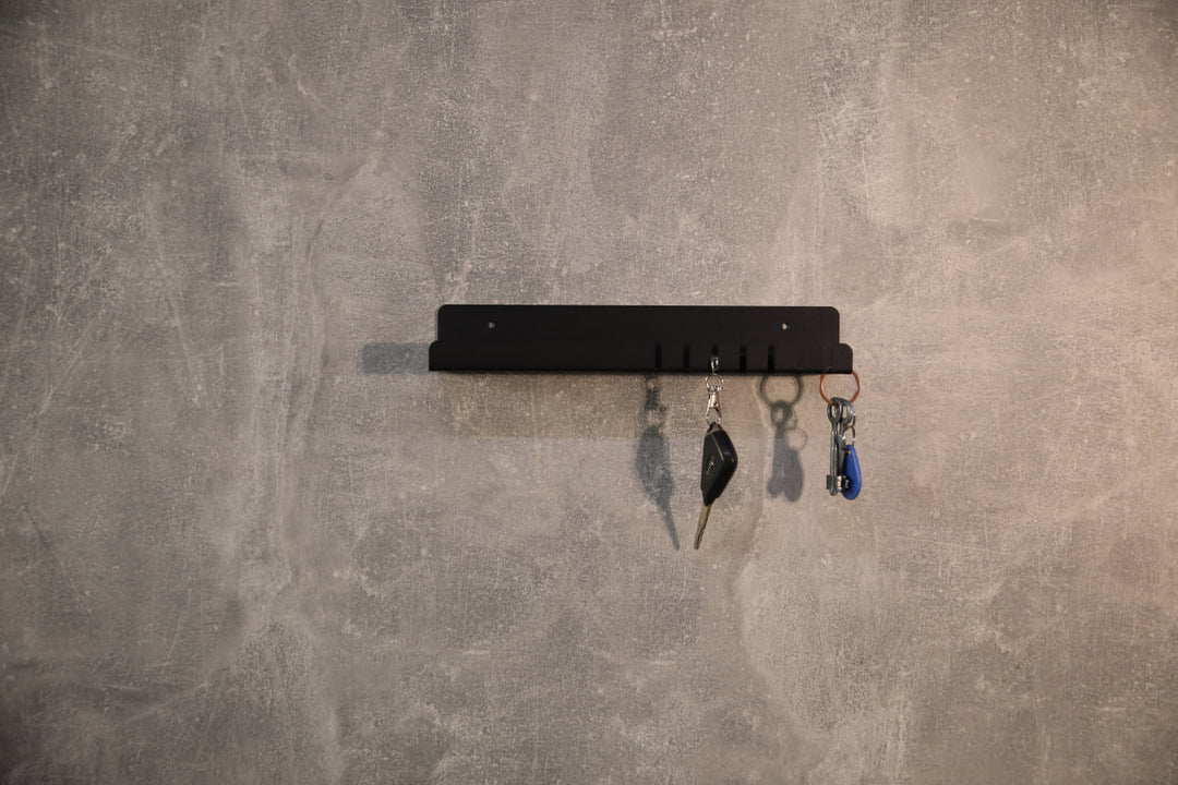 Wall-mounted-metal-key-holder-with-hooks-and-a-small-shelf-for-storing-keys-mail