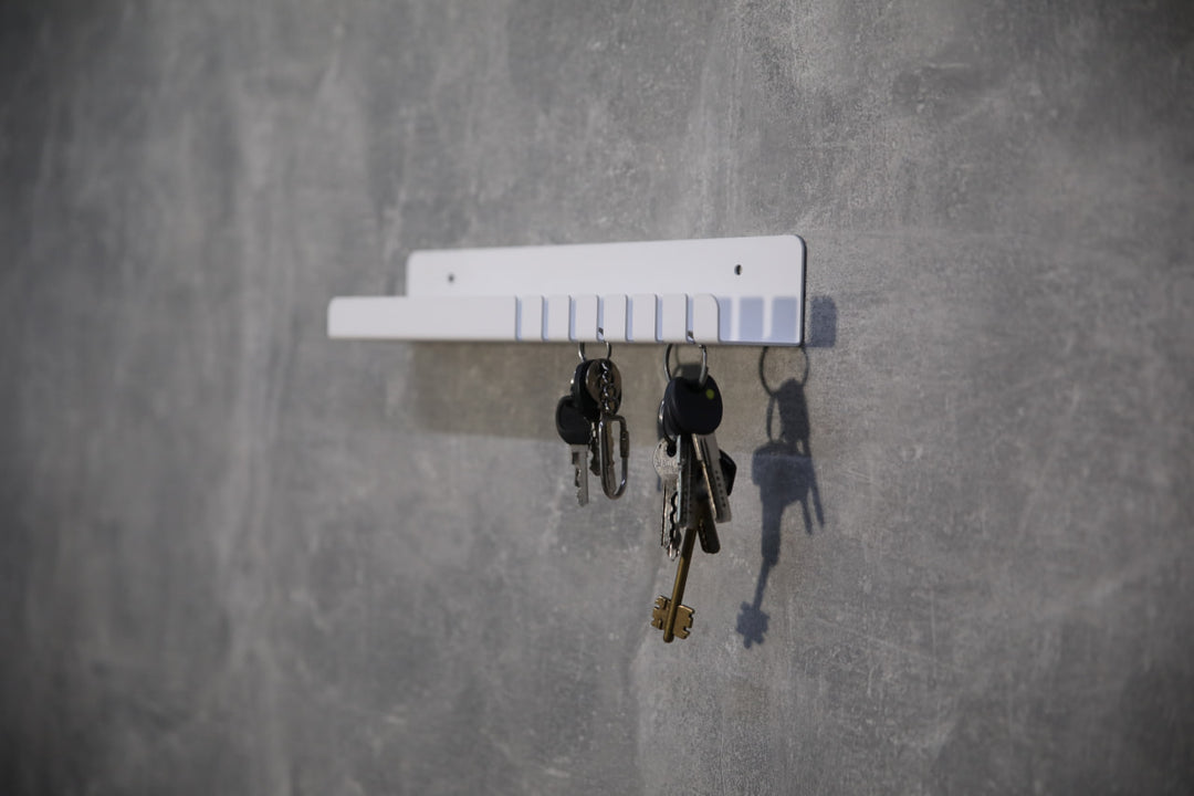 Wall-mounted-metal-key-holder-with-hooks-and-a-small-shelf-for-storing-keys-mail
