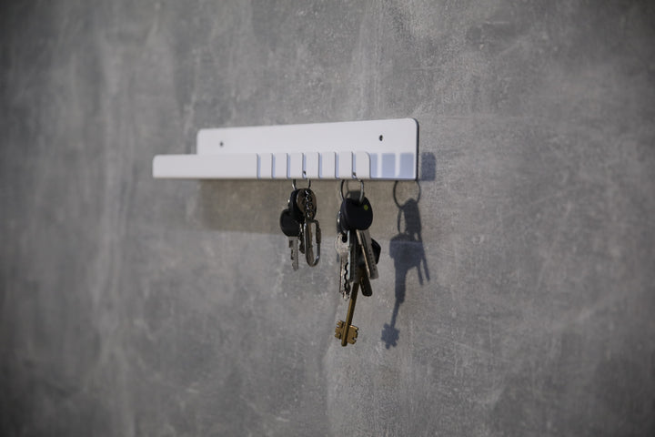 Wall-mounted-metal-key-holder-with-hooks-and-a-small-shelf-for-storing-keys-mail
