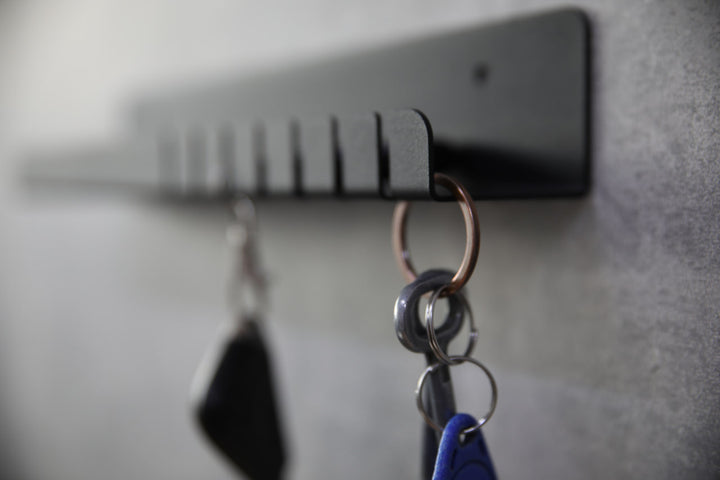 Wall-mounted-metal-key-holder-with-hooks-and-a-small-shelf-for-storing-keys-mail