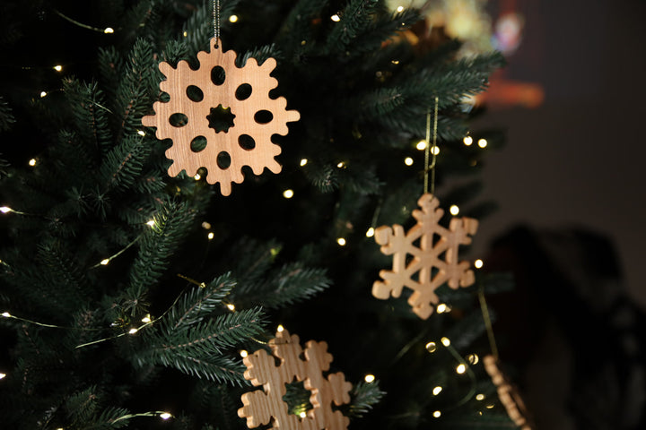 Natural-ash-wood-snowflake-ornament-with-detailed-carving-and-smooth-finish