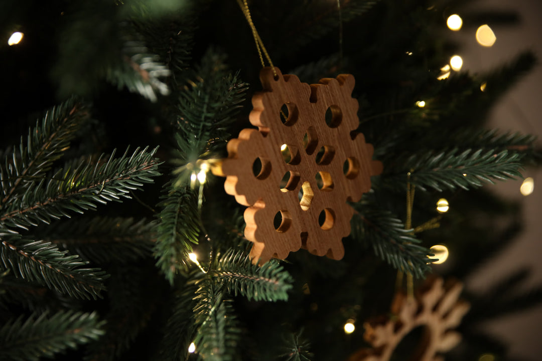Natural-ash-wood-snowflake-ornament-with-detailed-carving-and-smooth-finish