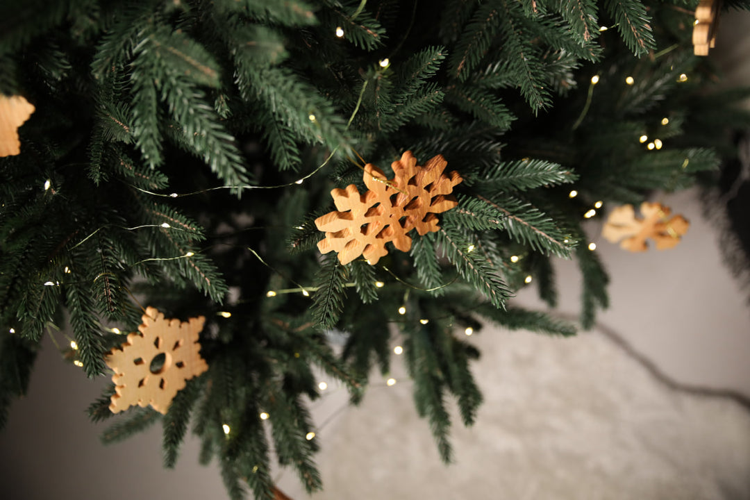 Natural-ash-wood-snowflake-ornament-with-detailed-carving-and-smooth-finish