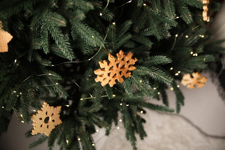 Natural-ash-wood-snowflake-ornament-with-detailed-carving-and-smooth-finish