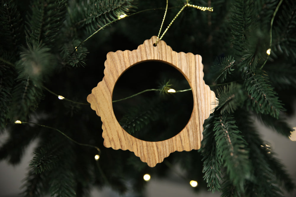 Natural-ash-wood-snowflake-ornament-with-detailed-carving-and-smooth-finish