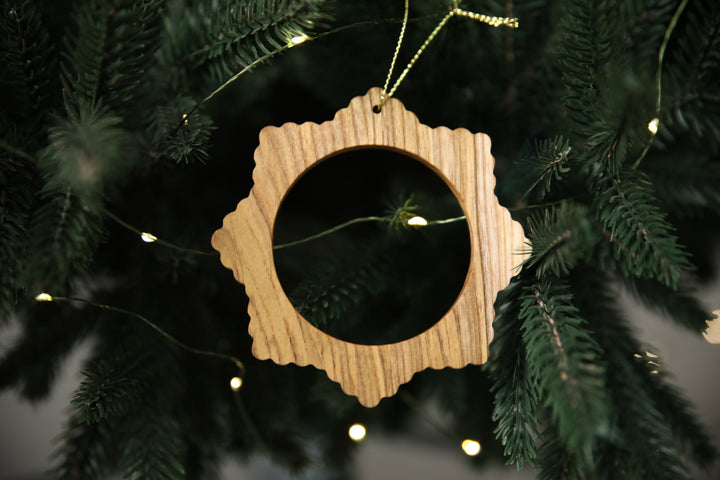 Natural-ash-wood-snowflake-ornament-with-detailed-carving-and-smooth-finish