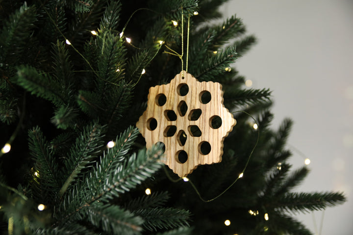 Natural-ash-wood-snowflake-ornament-with-detailed-carving-and-smooth-finish