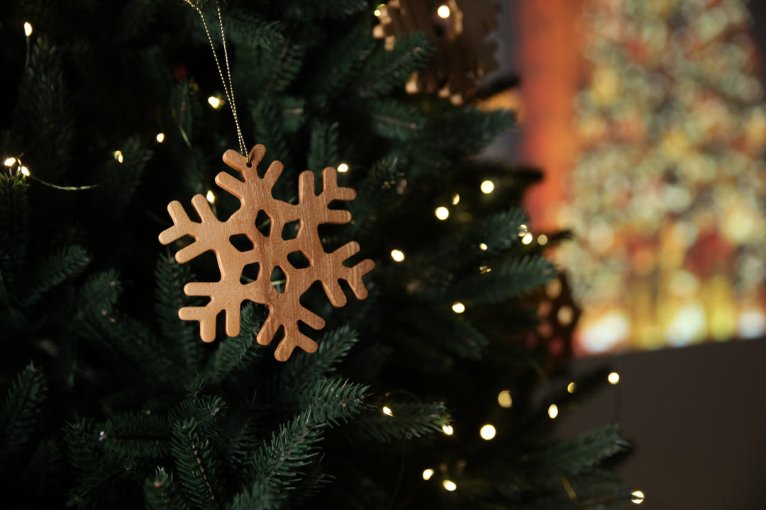 Natural-ash-wood-snowflake-ornament-with-detailed-carving-and-smooth-finish