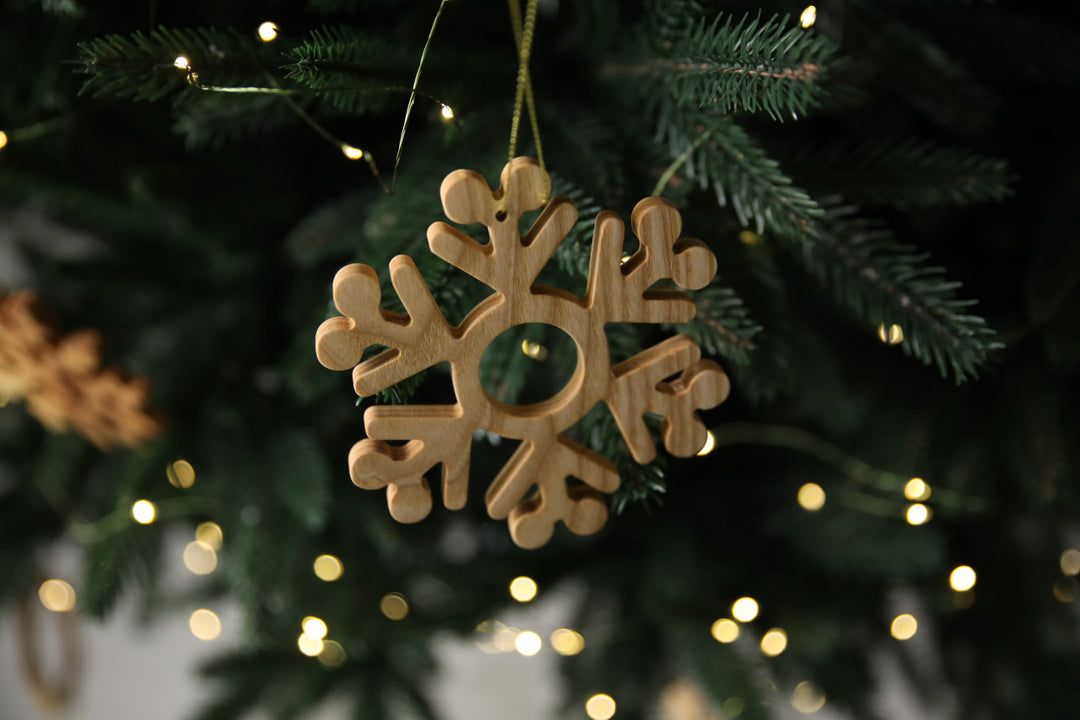 Natural-ash-wood-snowflake-ornament-with-detailed-carving-and-smooth-finish