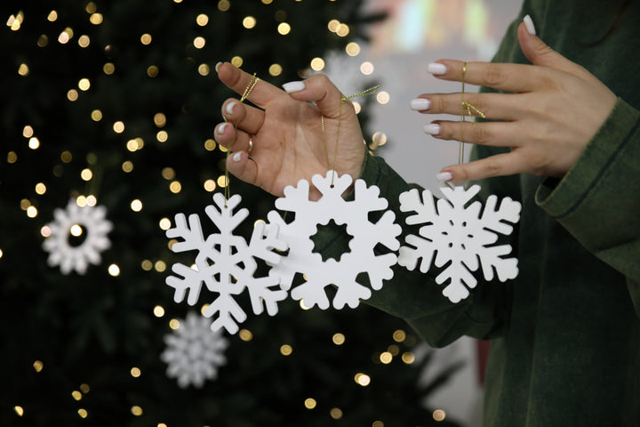 Hands-showing-white-plywood-snowflake-Christmas-decorations