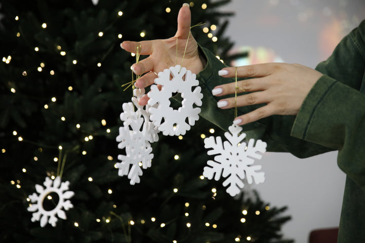 Hands-showing-white-plywood-snowflake-Christmas-decorations
