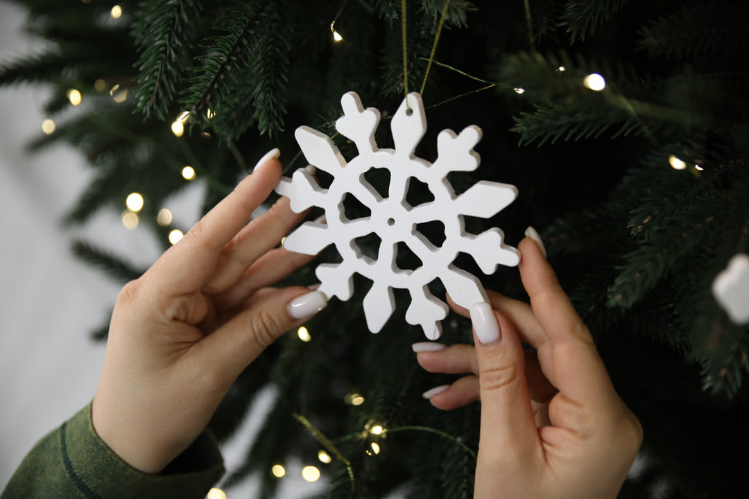 Hands-showing-white-plywood-snowflake-Christmas-decorations